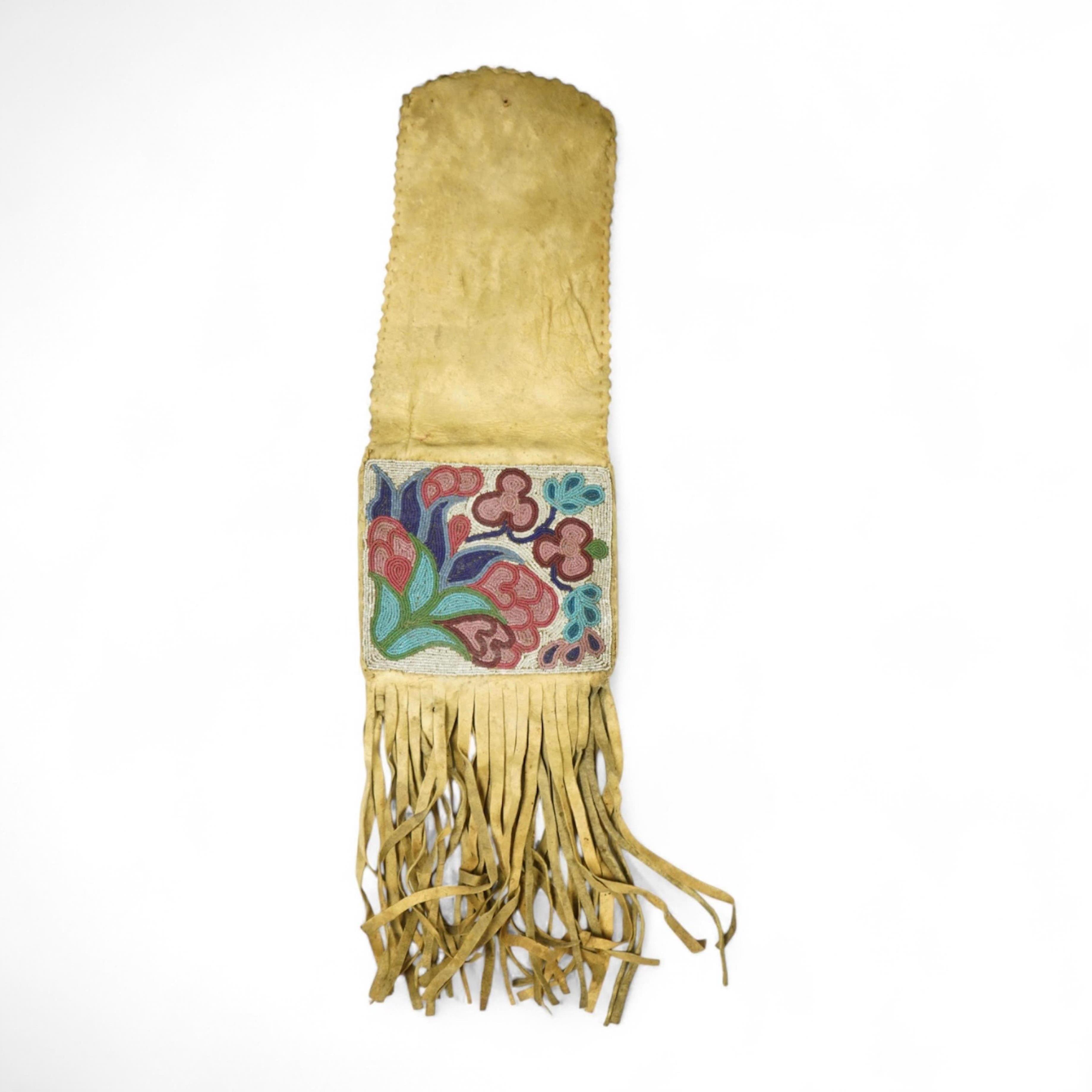 A late 19th century Native American beaded and fringed hide bag. With two different decorative beaded panels front and back. Possibly Cree. 60cm long. Condition - both panels of beadwork are in good condition. The hide a